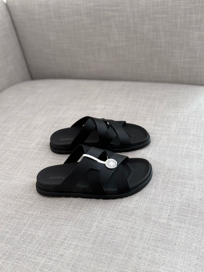 Hermès Kazimir sandal, crafted from black leather and fabric straps featuring an interlaced "H" silhouette.